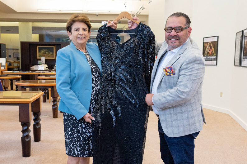 Gladys Gomez-Rossie, left, with the Cuban Heritage Collection, displays the dress worn by singer Celia Cruz, with Omer Pardillo, the former publicist and manager of the famous Cuban artist. 